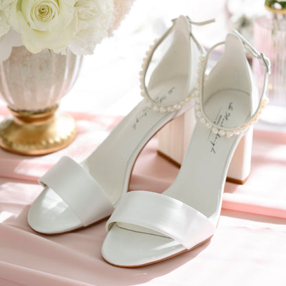 “Ivory satin bridal shoes with removable freshwater pearl strap, adjustable ankle strap, soft gel leather insole, and 7.5 cm (2.95 in) block heel